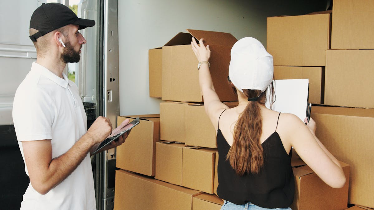Two workers reviewing package loading and route readiness near a delivery vehicle