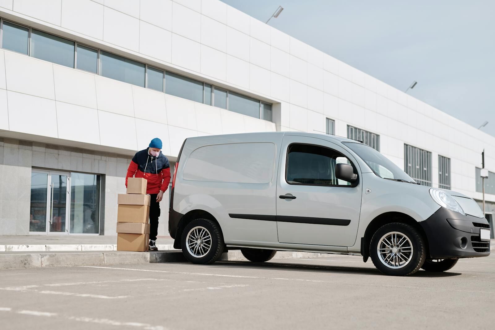 Delivery driver loading parcels into a cargo van before a route